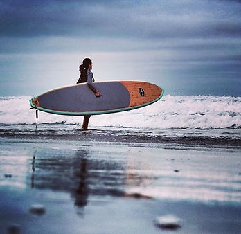 a man in a wet suit carrying a surf board